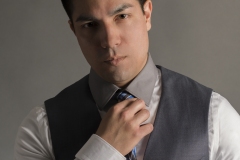 young man in business suit fixing tie